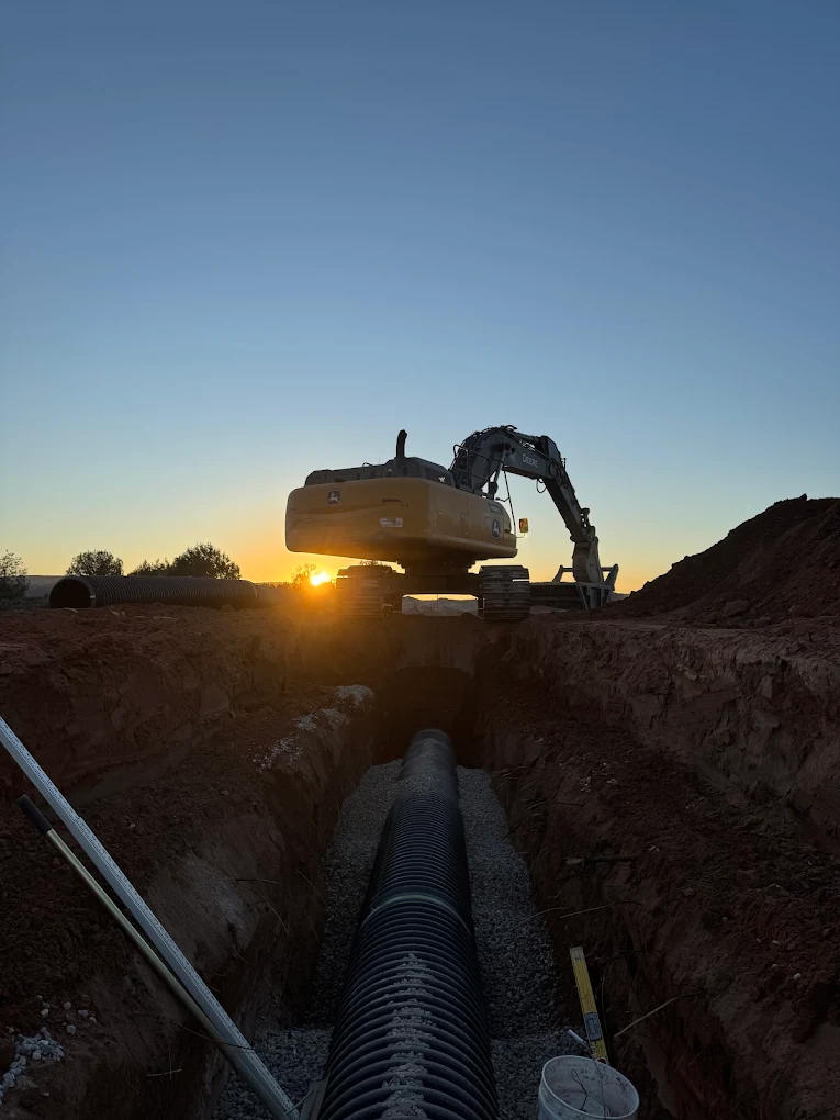 Trench work at sunset with drainage pipe